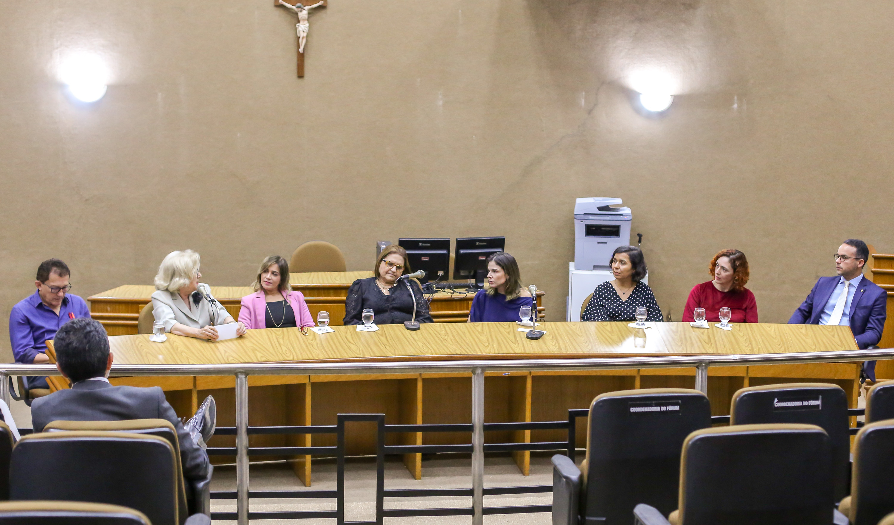 pessoas sentadas numa mesa de auditório